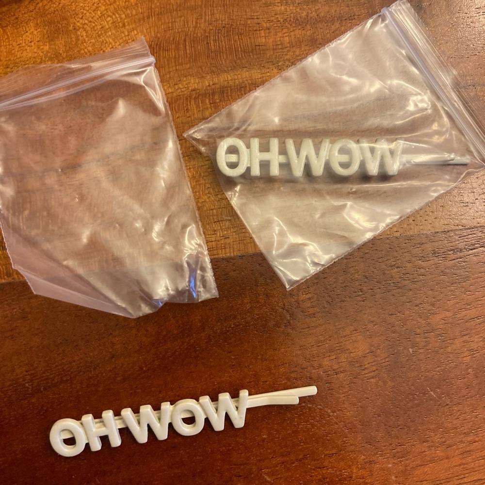 new set of two bobby pins for hair with saying “oh wow”